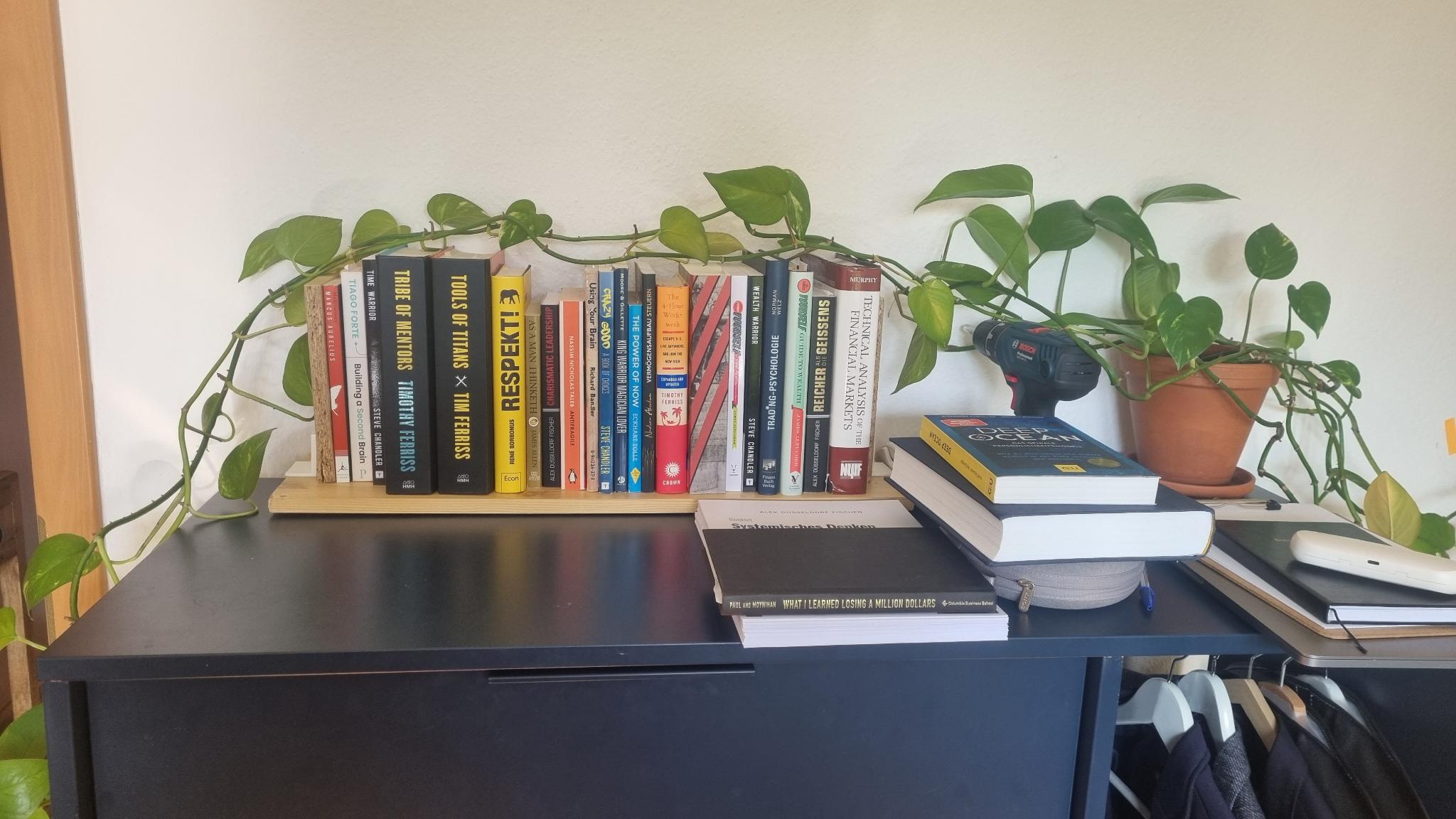 Small bookshelf on a dresser with plants on top